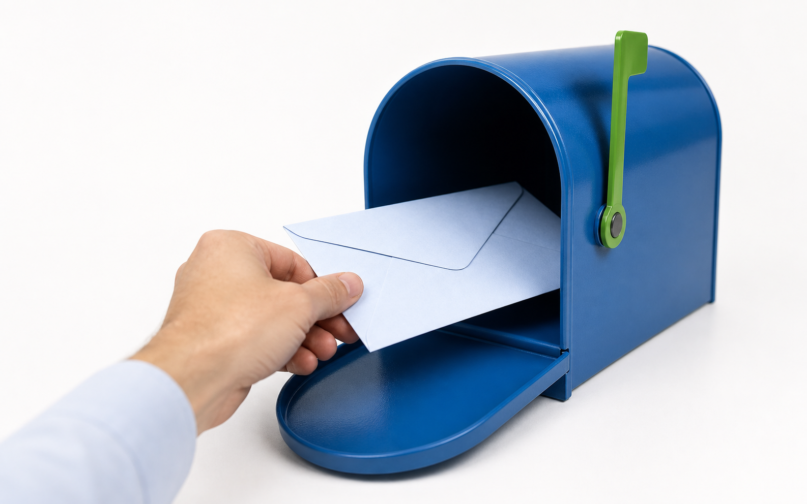 A hand placing a pale-blue letter into a blue mailbox